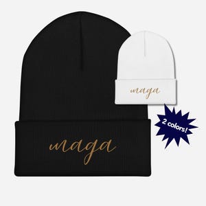 May include: Black and white knit beanie with the word "maga" embroidered in gold script. The beanie is available in two colors.