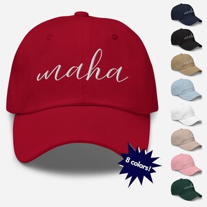 May include: A red baseball cap with the word "maha" embroidered in white on the front. The cap is available in 8 colors.