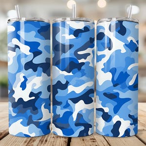 Könnte beinhalten: Drei isolierte Edelstahlbecher mit blauem Camouflagemuster. Jeder Becher hat einen transparenten Strohhalm und einen silbernen Deckel. Das Camouflagemuster verwendet Blau- und Weißtöne für ein modernes Aussehen.