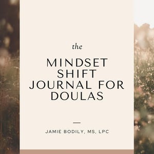 May include: A beige card with the text "the MINDSET SHIFT JOURNAL FOR DOULAS" and "JAMIE BODILY, MS, LPC" and "WWW.GROWTHTHRIVEDOULA.COM". The card is in front of a blurred background of green foliage and sunlight.
