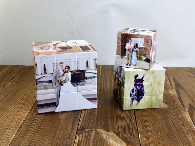 May include: Three personalized photo puzzle cubes. One cube features a wedding photo, while the other two display different images. The cubes are on a wooden surface, with a light-colored background.