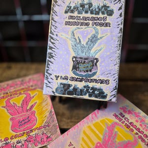 May include: Three rectangular art prints featuring a central potted plant illustration. The top print has a lavender background with black text reading RECLAMAMOS NUESTRO PODER Y LO COMPARTIMOS. The bottom prints feature yellow backgrounds with pink plants.