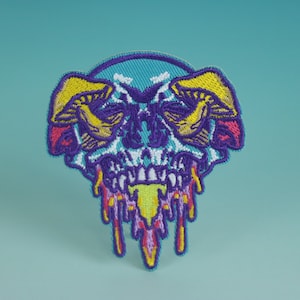Peut inclure: Un patch brodé coloré représentant un crâne avec deux champignons poussant de ses orbites. Le crâne coule d'un liquide coloré, créant un effet psychédélique.