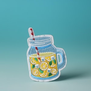 Könnte beinhalten: Ein weißer gestickter Aufnäher mit einem Einmachglas, gefüllt mit Limonade und einem rot-weiß gestreiften Strohhalm. Das Glas hat einen blauen Deckel und einen blauen Griff.
