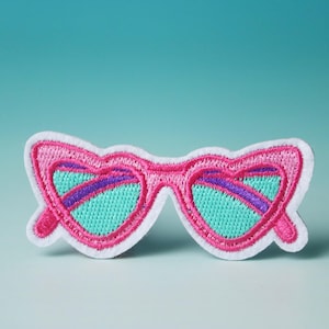 May include: Pink and white embroidered patch of a pair of sunglasses with turquoise lenses.