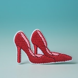 Peut inclure: Patch thermocollant brodé rouge d'une paire de chaussures à talons hauts.