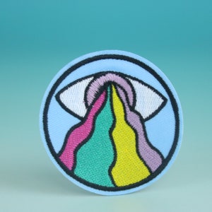 May include: A round, blue embroidered patch with a white eye that is crying a rainbow of pink, green, yellow, and purple.