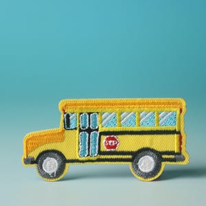 May include: A yellow school bus embroidered patch with a stop sign and windows. The patch is on a blue background.
