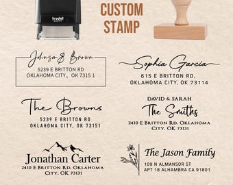 Può includere: Una collezione di timbri personalizzati, tra cui un timbro autoinchiostrante e un timbro in legno. L'immagine mostra vari design con nomi e indirizzi, come "Johnson & Brown" e "The Smiths", con il testo "CUSTOM STAMP".