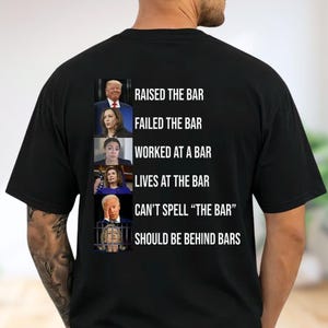 May include: A black t-shirt featuring a vertical column of six political figures alongside text. The text reads: RAISED THE BAR, FAILED THE BAR, WORKED AT A BAR, LIVES AT THE BAR, CAN'T SPELL "THE BAR", and SHOULD BE BEHIND BARS.