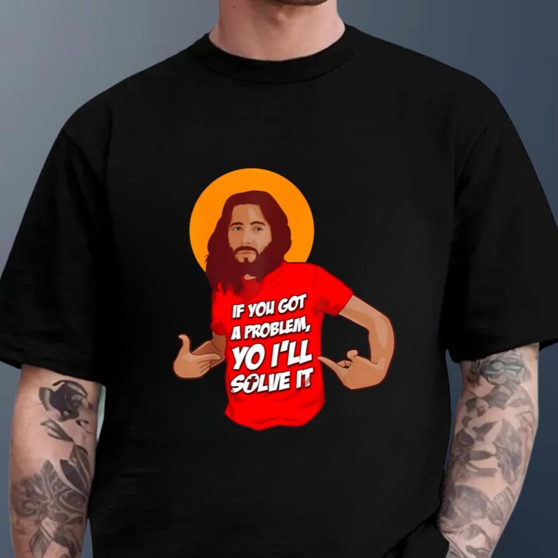 A black t-shirt with a graphic design depicting a man with a beard wearing a red shirt with the text "If you got a problem, you'll solve it" printed on it.