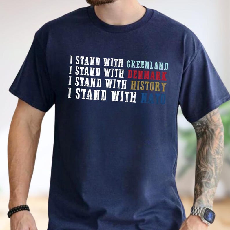 A man wearing a navy blue t-shirt with text printed on it.