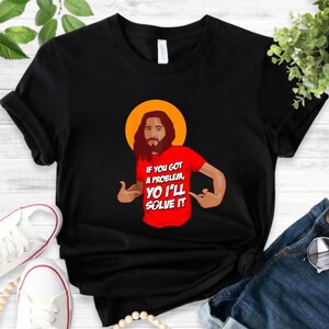 A black t-shirt with a graphic design depicting a man with a beard wearing a red shirt and the text "If you got a problem, you'll solve it" printed on it.