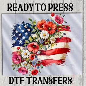 May include: A red, white and blue American flag with a floral design. The flag is surrounded by red, white and pink flowers. The text "READY TO PRESS" is at the top of the image and the text "DTG TRANSFERS" is at the bottom of the image.