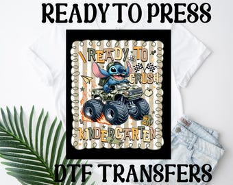 May include: A DTF transfer featuring Stitch from Lilo & Stitch driving a monster truck. The design includes the text "READY TO CRUSH KINDERGARTEN". The image is set against a white background.