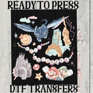 May include: Black DTF transfer design with cartoon characters and elements. Includes a dragon, castle, and the text "EPIC UNIVERSE". Also features Mario and Luigi characters, a star, and a mushroom.