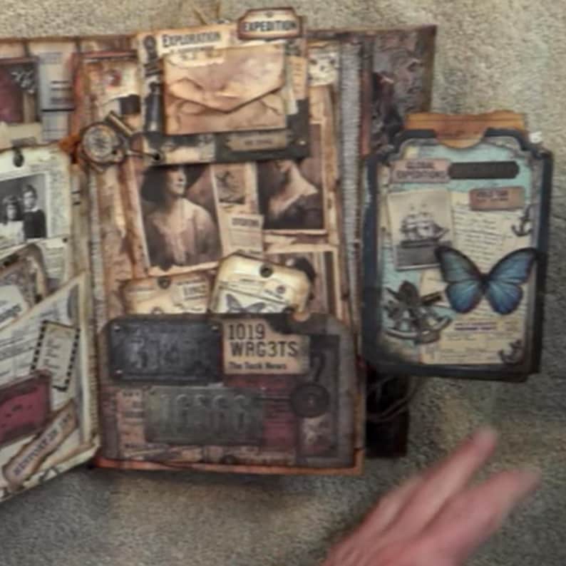May include: A vintage-style scrapbook featuring layered paper ephemera, sepia-toned portraits, and a prominent blue butterfly illustration. The pages include text labels like Exploration, Expedition, and 1019 WRG3TS, with nautical motifs and metal-look accents.