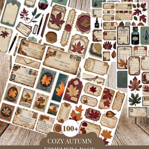 May include: A collection of vintage-style ephemera with a cozy autumn theme. The pack includes tags, labels, and stationery with fall leaf and botanical designs in shades of brown, burgundy, and teal. The text "COZY AUTUMN EPHEMERA PACK" is visible.