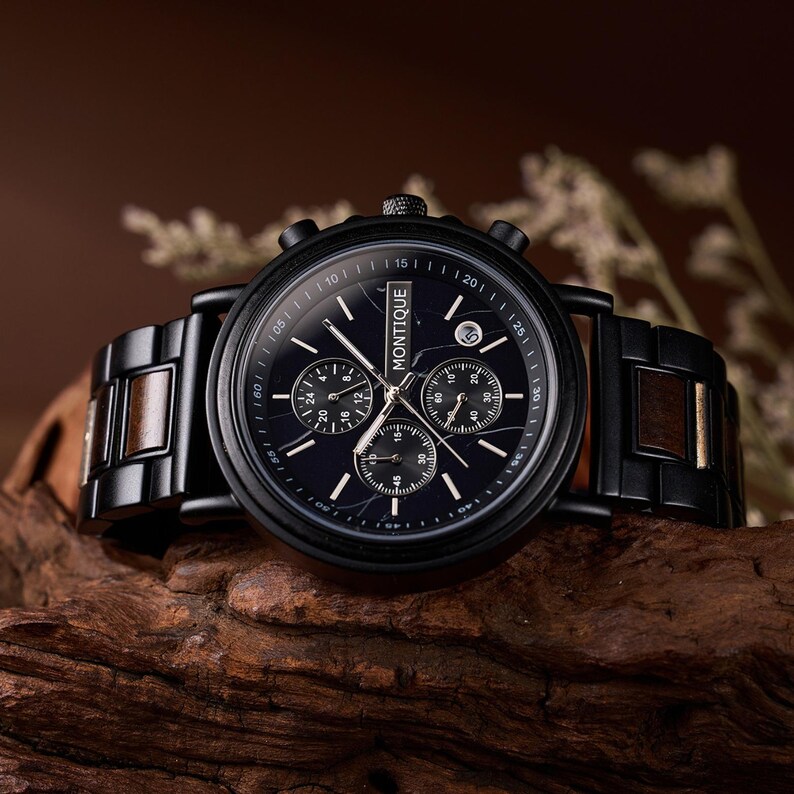 May include: A black wristwatch with a dark face and wooden accents on the band. The watch face features multiple sub-dials and the brand name "MONTIQUE". The watch is displayed on a wooden surface.