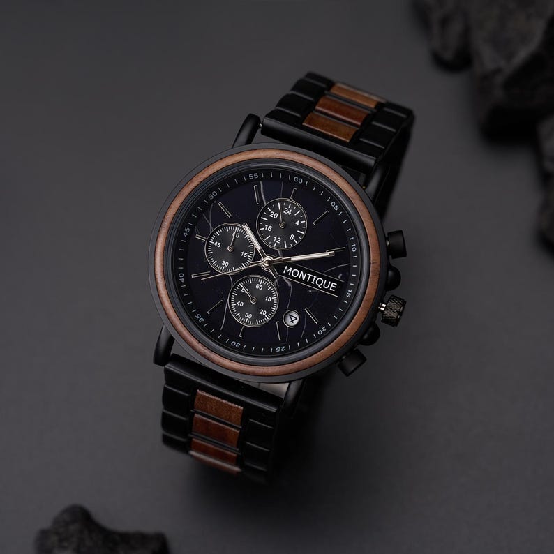 May include: A black Montique wristwatch with a dark blue face, featuring sub-dials and a date window. The watch has a brown wooden bezel and accents on the black metal band. A stylish accessory.