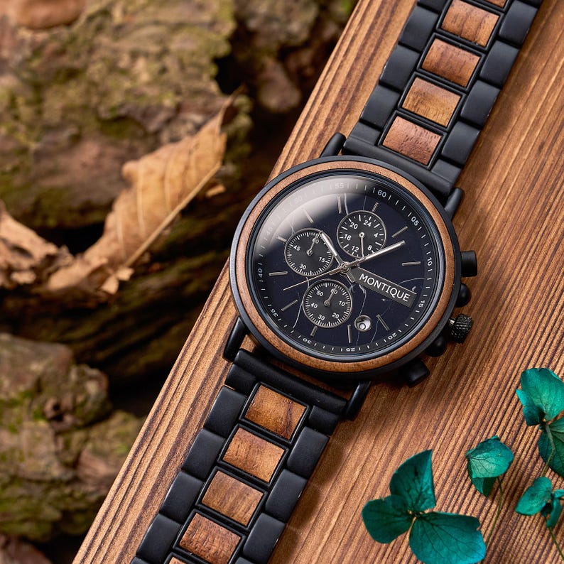 May include: A black wristwatch with a wooden bezel and band links. The watch face is dark blue with three sub-dials and the word "MONTIQUE" printed in white. The watch is displayed on a wooden surface.