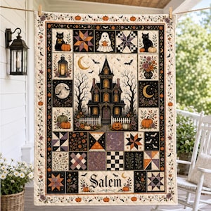 May include: A rectangular quilt featuring a central haunted house illustration, surrounded by blocks depicting black cats, ghosts, pumpkins, lanterns, and floral arrangements. The quilt includes the text Salem and a decorative border of vines.