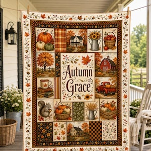 May include: A rectangular quilt featuring a patchwork design with autumn-themed illustrations including pumpkins, a farmhouse, a red barn, a squirrel, and a red truck. The center panel displays the text Autumn Grace surrounded by fall foliage.