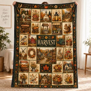 May include: A rectangular throw blanket featuring a grid of autumn-themed illustrations including houses, pumpkins, sunflowers, a squirrel, a rabbit, a red barn, and a windmill. The center panel displays the word HARVEST in gold lettering.