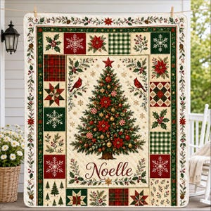 May include: A rectangular quilt featuring a central Christmas tree decorated with ornaments and poinsettias, flanked by two red cardinals. The name Noelle is printed below the tree. The border consists of patchwork squares with snowflakes, plaid, and holly.