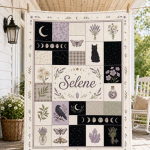 May include: A rectangular quilt featuring a patchwork design with the name Selene in the center. The quilt displays illustrations of a black cat, a raven, moths, moon phases, lavender, crystals, and stars in shades of purple, black, and cream.