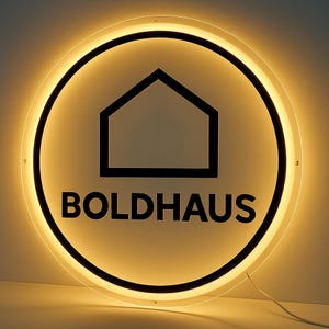 Peut inclure: Un panneau rond et lumineux avec le mot "BOLDHAUS" en lettres noires grasses. Le panneau pr&eacute;sente un contour de maison noir &agrave; l'int&eacute;rieur d'un cercle, entour&eacute; d'une lumi&egrave;re chaude et brillante. Un fil blanc s'&eacute;tend du bas.