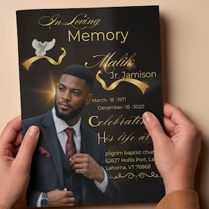 Peut inclure: Une carte comm&eacute;morative tenue par des mains, avec le portrait d'un homme en costume. La carte porte l'inscription dor&eacute;e "In Loving Memory" et le nom "Malik Jr. Jamison". Les dates de naissance et de d&eacute;c&egrave;s sont &eacute;galement incluses.
