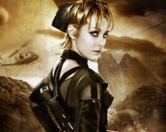 May include: A woman in a black and brown leather outfit with a futuristic design. She is wearing a black and white patterned shirt and a black hat with a white trim. She is holding a weapon in her right hand.