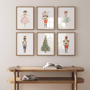 May include: Six framed watercolor illustrations featuring a Nutcracker, a Christmas tree, a mouse, and ballerinas. The illustrations are in a whimsical style with gold accents.