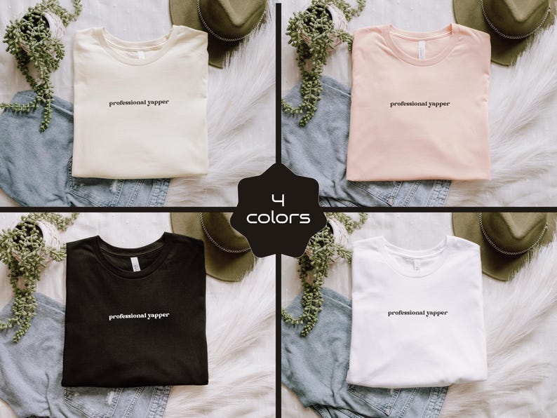 May include: Four t-shirts in cream, pink, black, and white, each with the text "professional yapper" in a simple font. The shirts are displayed on a white fur-like surface with denim and hats.