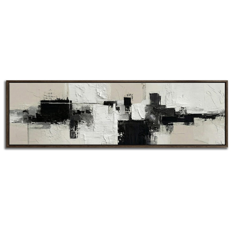 May include: Abstract art painting in a rectangular, dark brown wooden frame. The artwork features a textured, layered design with black, white, and beige tones. The composition is a modern, geometric arrangement of shapes and brushstrokes.