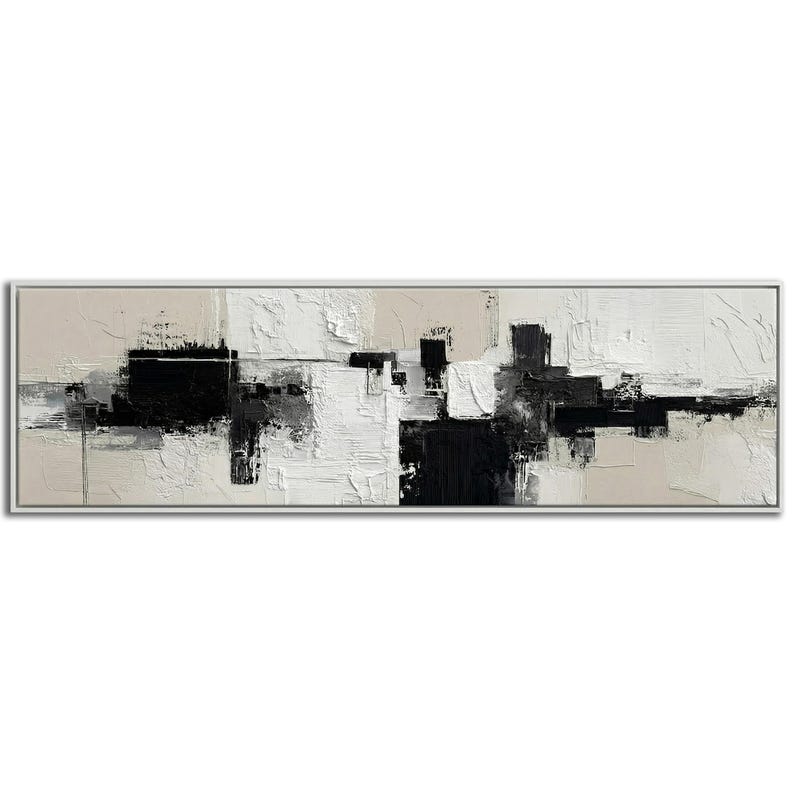 May include: Abstract art painting in a rectangular white frame. The artwork features a textured, layered design with blocks of black, white, and beige. The composition is a modern, minimalist style, suitable for home decor.
