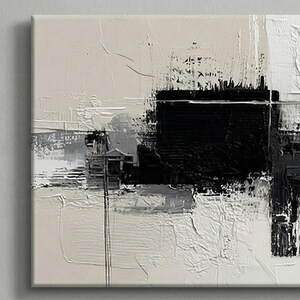 May include: Abstract art piece with a textured surface. The artwork features a bold black square at the center, contrasted by white, gray, and beige brushstrokes. The composition is a modern, minimalist design.