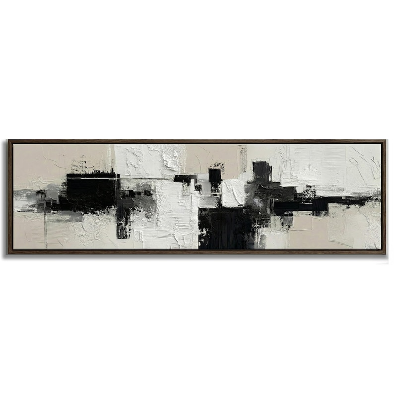 May include: Abstract art painting in a rectangular dark wood frame. The artwork features a textured, layered design in black, white, and beige tones. The composition is a modern, minimalist style, suitable for home decor.