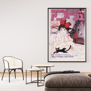 May include: A framed anime poster featuring a girl with a red bow and a black cat. The poster is in a living room setting with a white chair, two small tables, and a large plant in a white pot. The poster has Japanese text.