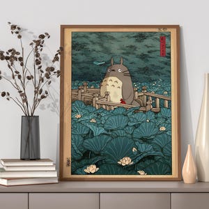 May include: Framed art print depicting a large, grey, furry creature on a wooden bridge, surrounded by lily pads. The artwork has a Japanese aesthetic with a muted colour palette of greens, blues, and browns. The frame is a warm brown colour.