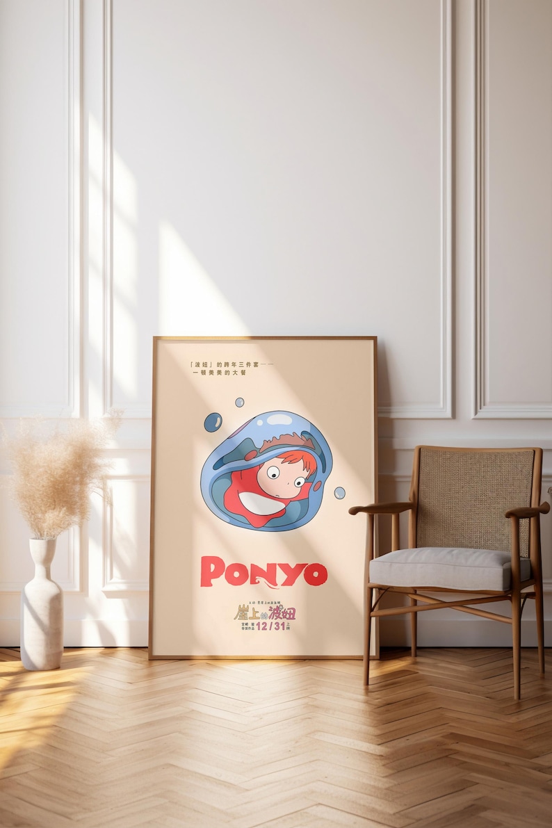 Puede incluir: Un p&oacute;ster enmarcado de la pel&iacute;cula de animaci&oacute;n "Ponyo". La obra de arte muestra un personaje dentro de una burbuja azul, con el t&iacute;tulo de la pel&iacute;cula en rojo. El p&oacute;ster se exhibe en una habitaci&oacute;n con suelo de madera y una silla.