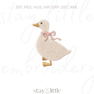 May include: An embroidered duck with a pink bow around its neck. The duck is off-white with a textured appearance, a yellow beak and feet. The text "stay little embroidery" is at the bottom.