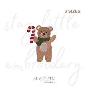 May include: Embroidered design of a teddy bear holding a red and white candy cane, wearing a green scarf. The bear is light brown with a cream-colored belly. The text "3 SIZES" is above the bear. The text "stay little embroidery" is below the bear.
