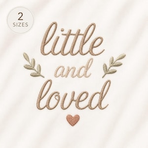 Könnte beinhalten: Ein Stickmuster auf weißem Stoff mit dem Text "little and loved" in brauner Schreibschrift. Zwei kleine grüne Blattzweige flankieren das Wort "and" und ein kleines braunes Herz befindet sich unter dem Wort "loved".