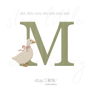Könnte beinhalten: Ein gesticktes Design mit dem Buchstaben "M" in einem gedämpften Grünton, mit einer bezaubernden Gans mit einer rosa Schleife. Das Design enthält den Text "stay little embroidery" unten und Dateityp-Abkürzungen oben.