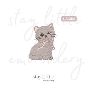 May include: An embroidery design of a grey kitten with large dark eyes, pink inner ears, and a light pink bow tied around its neck. The design features the text 3 SIZES in a rectangular box and the text stay little embroidery at the bottom.