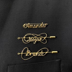 May include: Three gold wire name pins with the names "Amanda", "Megan", and "Brenda" written in cursive.