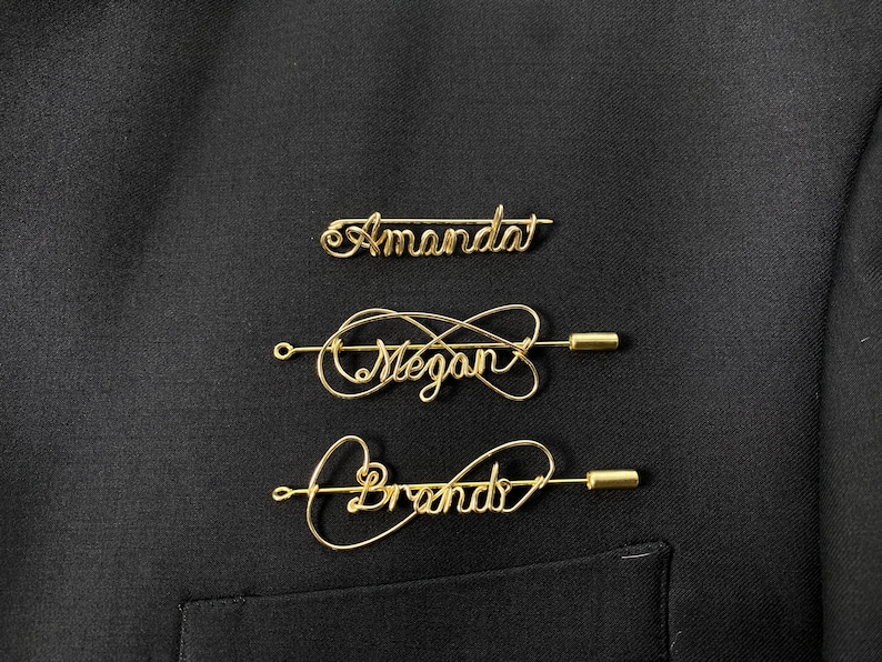 May include: Three gold wire name pins with the names "Amanda", "Megan", and "Brenda" written in cursive.
