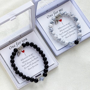 May include: Two small white boxes with black and white beaded bracelets inside. Each box has a card with the text "One for you" and "One for me" and a message about being there for each other.